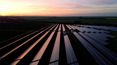 Birleşik Krallık 'taki altın saat boyunca gün batımında muazzam bir güneş enerjisi santralinin çarpıcı hava manzarası.