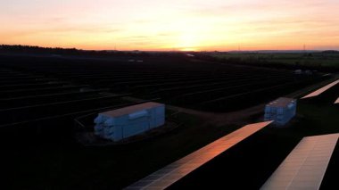 Birleşik Krallık 'taki altın saat boyunca gün batımında muazzam bir güneş enerjisi santralinin çarpıcı hava manzarası.