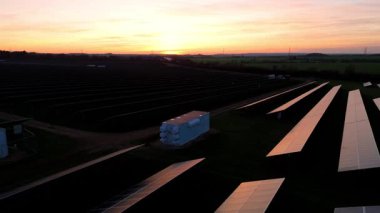 Birleşik Krallık 'taki altın saat boyunca gün batımında muazzam bir güneş enerjisi santralinin çarpıcı hava manzarası.