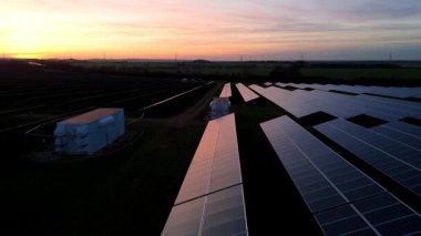 Birleşik Krallık 'taki altın saat boyunca gün batımında muazzam bir güneş enerjisi santralinin çarpıcı hava manzarası.