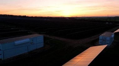 Birleşik Krallık 'taki altın saat boyunca gün batımında muazzam bir güneş enerjisi santralinin çarpıcı hava manzarası.