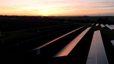 Birleşik Krallık 'taki altın saat boyunca gün batımında muazzam bir güneş enerjisi santralinin çarpıcı hava manzarası.