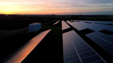 Birleşik Krallık 'taki altın saat boyunca gün batımında muazzam bir güneş enerjisi santralinin çarpıcı hava manzarası.