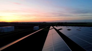 Birleşik Krallık 'taki altın saat boyunca gün batımında muazzam bir güneş enerjisi santralinin çarpıcı hava manzarası.