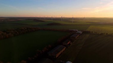 Newmarket, İngiltere yakınlarındaki altın saat boyunca gün batımında büyük bir rüzgar çiftliğinin çarpıcı hava manzarası