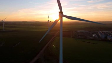 Newmarket, İngiltere yakınlarındaki altın saat boyunca gün batımında büyük bir rüzgar çiftliğinin çarpıcı hava manzarası