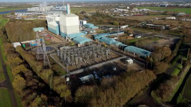 İngiltere 'deki büyük bir CCGT güç istasyonunun hava aracı görüntüsü, enerji üretimi için çoklu gaz türbin modülleri ve egzoz yığınları içeriyor.