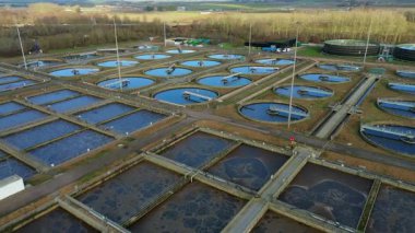 Büyük bir İngiliz kanalizasyon arıtma tesisinin hava aracı görüntüsü dairesel tortu tankları ve endüstriyel atık su işleme birimlerini gösteriyor..