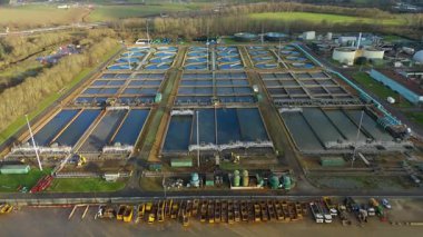 Büyük bir İngiliz kanalizasyon arıtma tesisinin hava aracı görüntüsü dairesel tortu tankları ve endüstriyel atık su işleme birimlerini gösteriyor..