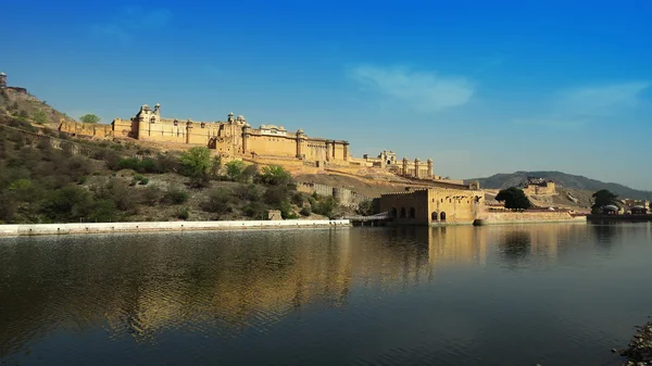 Alte prächtige Bernstein-Festung, die auf einem felsigen Hügel thront und sich im klaren Wasser des Sees spiegelt. jaipur, indien — Stockfoto