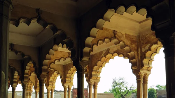 Stone colonnade at the exit of an old Indian palace on garden background — Stock Photo, Image