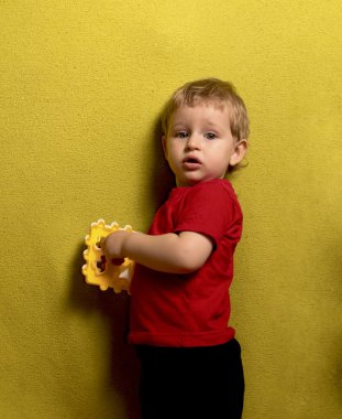 Sürpriz bakışla küçük sarışın çocuk oyuncak düşündüm elinde tutan