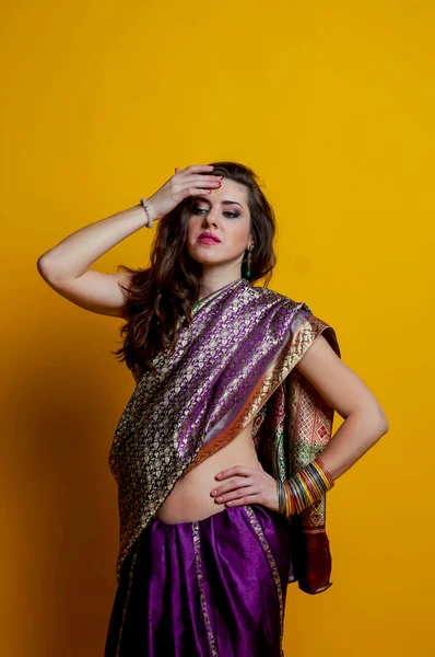 Mujer joven en un brillante saris indio tocó la frente para arreglar joyas. Estilo indio . — Foto de Stock