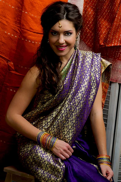 De jonge dark-haired vrouw in de rijke Indiase sari's en kleurrijke armbanden. Indiase stijl. — Stockfoto