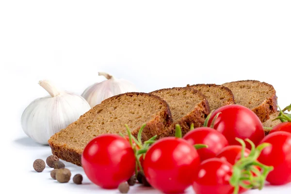 Skład chleba, kilka pomidory i czosnek — Zdjęcie stockowe