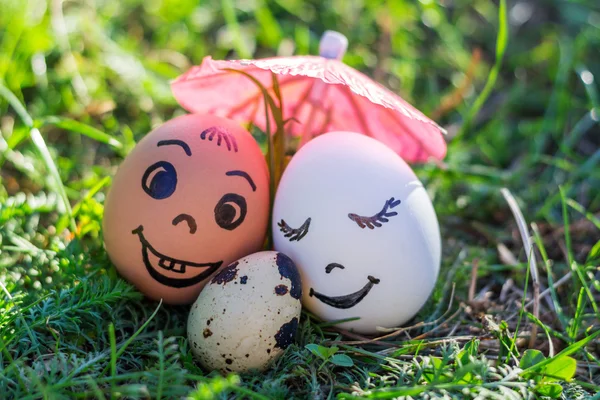 Huevos divertidos imitando sonriente pareja mixta con bebé versicolor — Foto de Stock