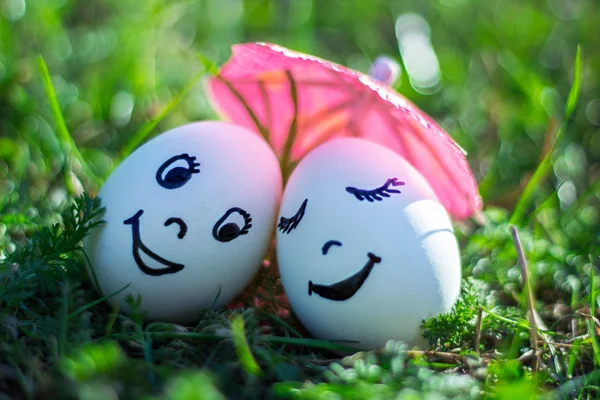 Αστεία αυγά μιμούνται ευτυχισμένο ζευγάρι από χαμογελαστά εραστές υπό ομπρέλα — Φωτογραφία Αρχείου