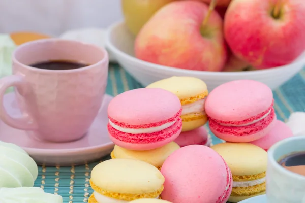 Bodegón de taza de café rosa, galletas de macarrones y manzanas — Foto de Stock