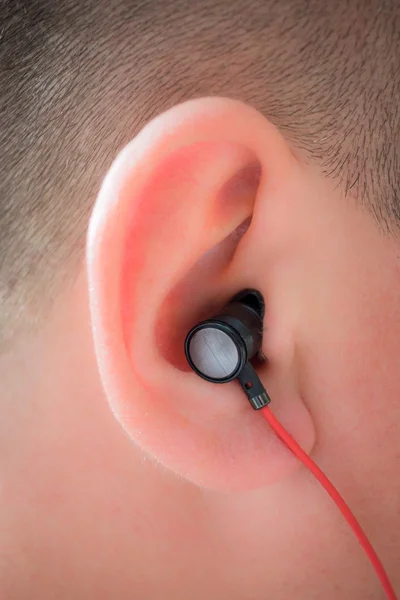 Man's human ear with wire earphone