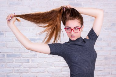 Genç kız kırmızı gözlük uzun saçlarını çeker