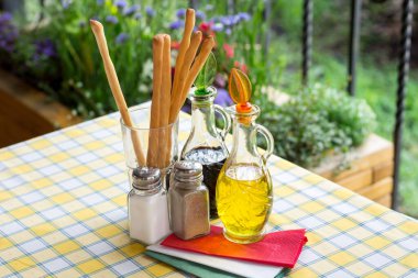 İtalyan servisi. Masa seti zeytin yağı, ekmek çubukları, tuz, karabiber.