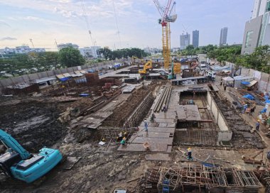 Monolitik yapı temelleri ve beton döşemeleri olan bir inşaat sahası. Bina inşaatında kule vinci.