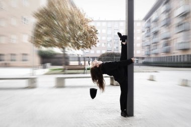 Şehir ortamında çağdaş bir dansçının hareketini donduran bir ekran görüntüsü.