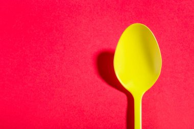 Sarı kaşık kırmızı zemine gölge düşürüyor