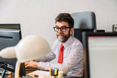 Video konferansı için sakallı ve gözlüklü orta yaşlı iş adamı.