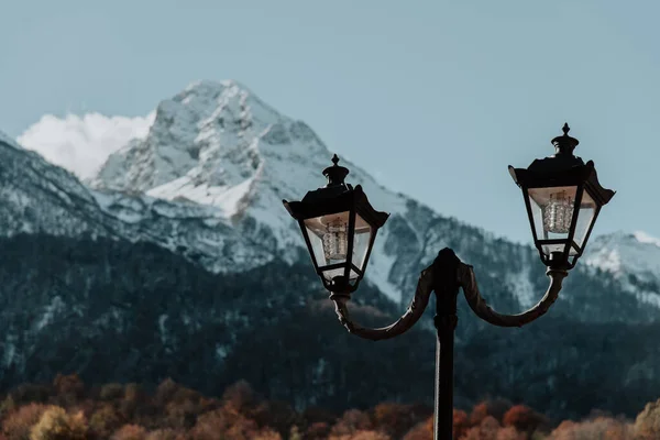 Adler, Rosa Khutor. Eski model sokak lambası. Karla kaplı dağların arkasında