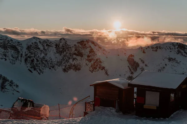 Adler, Rosa Khutor. Dağların tepesindeki ahşap evler, günbatımı zamanı..