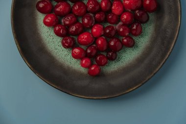Kalp şeklinde kızılcık, mavi bir arka planda. Manzara güzel, yemek kalp şeklinde. Sevgililer günü fotoğrafı.