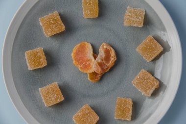 Kalp şeklinde malmalmalade ve kurutulmuş mandalina, mavi arka planda. Manzara güzel, yemek kalp şeklinde. Sevgililer günü fotoğrafı.