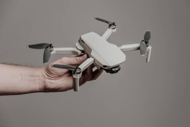 Eldeki kuadkopter gri arkaplanda izole edildi. Moskova, Rusya