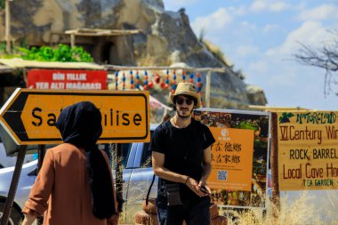Türkiye, Goreme - 22 Temmuz 2021: Yol İşareti Yakınındaki Güneş Gözlüklü Beyaz Turist