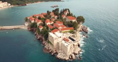 Karadağ 'ın Adriyatik kıyısındaki Saint Stephen (Sveti Stefan) adasına 4K Hava Görüntüsü