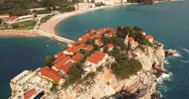 Karadağ 'ın Adriyatik kıyısındaki Saint Stephen (Sveti Stefan) adasına 4K Hava Görüntüsü