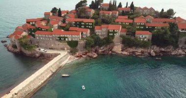 Karadağ 'ın Adriyatik kıyısındaki Saint Stephen (Sveti Stefan) adasına 4K Hava Görüntüsü