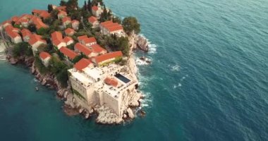 Karadağ 'ın Adriyatik kıyısındaki Saint Stephen (Sveti Stefan) adasına 4K Hava Görüntüsü