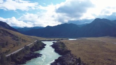 Rusya 'nın Altai Dağları' ndaki Kimyasal Trakt üzerinde Oroktoy yerleşim alanı yakınlarındaki Katun Nehri üzerindeki Sonbahar Peyzaj ve Köprüsünün 4K Hava Görüntüsü