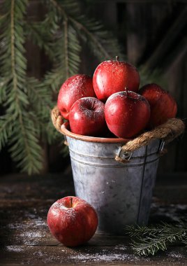 Ahşap bir masada kırmızı elmalarla dolu bir hayat.