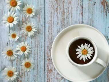 Papatya çiçekli bir fincan çay.