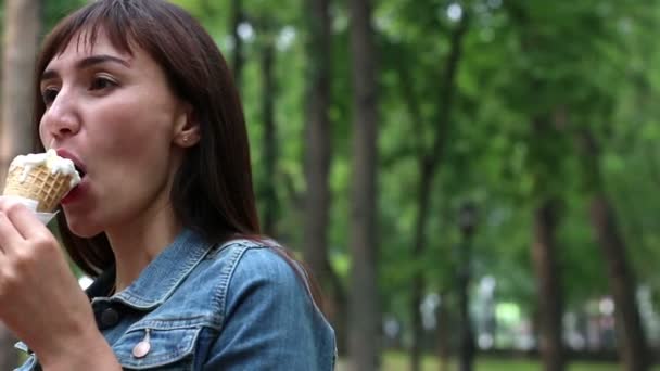 Hermosa mujer comiendo helado en el parque, de cerca — Vídeo de stock