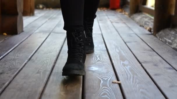Γυναίκα είναι το περπάτημα στο ξύλινο πάτωμα, στη βεράντα κατά τη διάρκεια της ημέρας το φθινόπωρο — Αρχείο Βίντεο