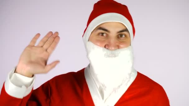 Pria berjas Santa Claus melambaikan tangan. Menyapa atau mengucapkan selamat tinggal terhadap latar belakang putih. — Stok Video