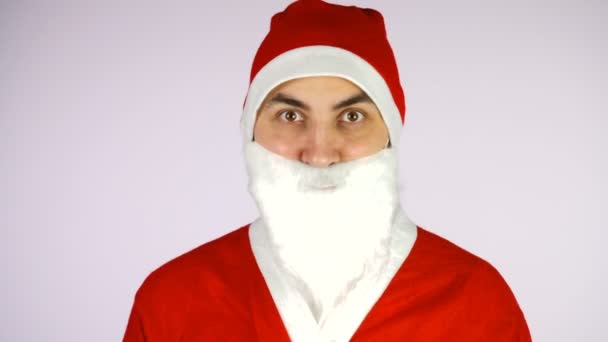 Porträt eines glücklichen jungen Mannes im Weihnachtsmann-Anzug auf weißem Hintergrund — Stockvideo