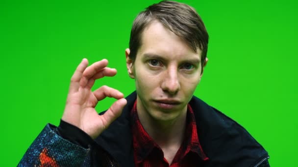 Молодой человек в повседневной одежде показывает ОК руку знак на зеленом фоне экрана. — стоковое видео
