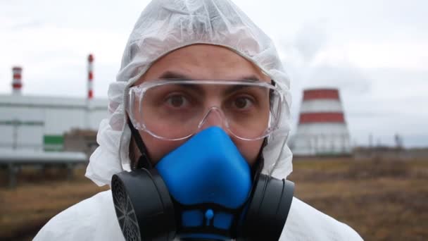 Retrato del hombre de ecología en traje protector y respirador en el fondo de la fábrica industrial — Vídeo de stock