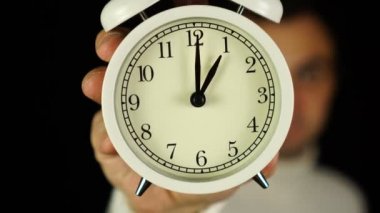 1 kilit. Bir kilit ve çınlama gösteren alarmlı saati tutan insan eli..