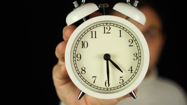 Ve 4:30. Lidská ruka držící budík, který ukazuje půl páté hodiny a zvoní. — Stock video